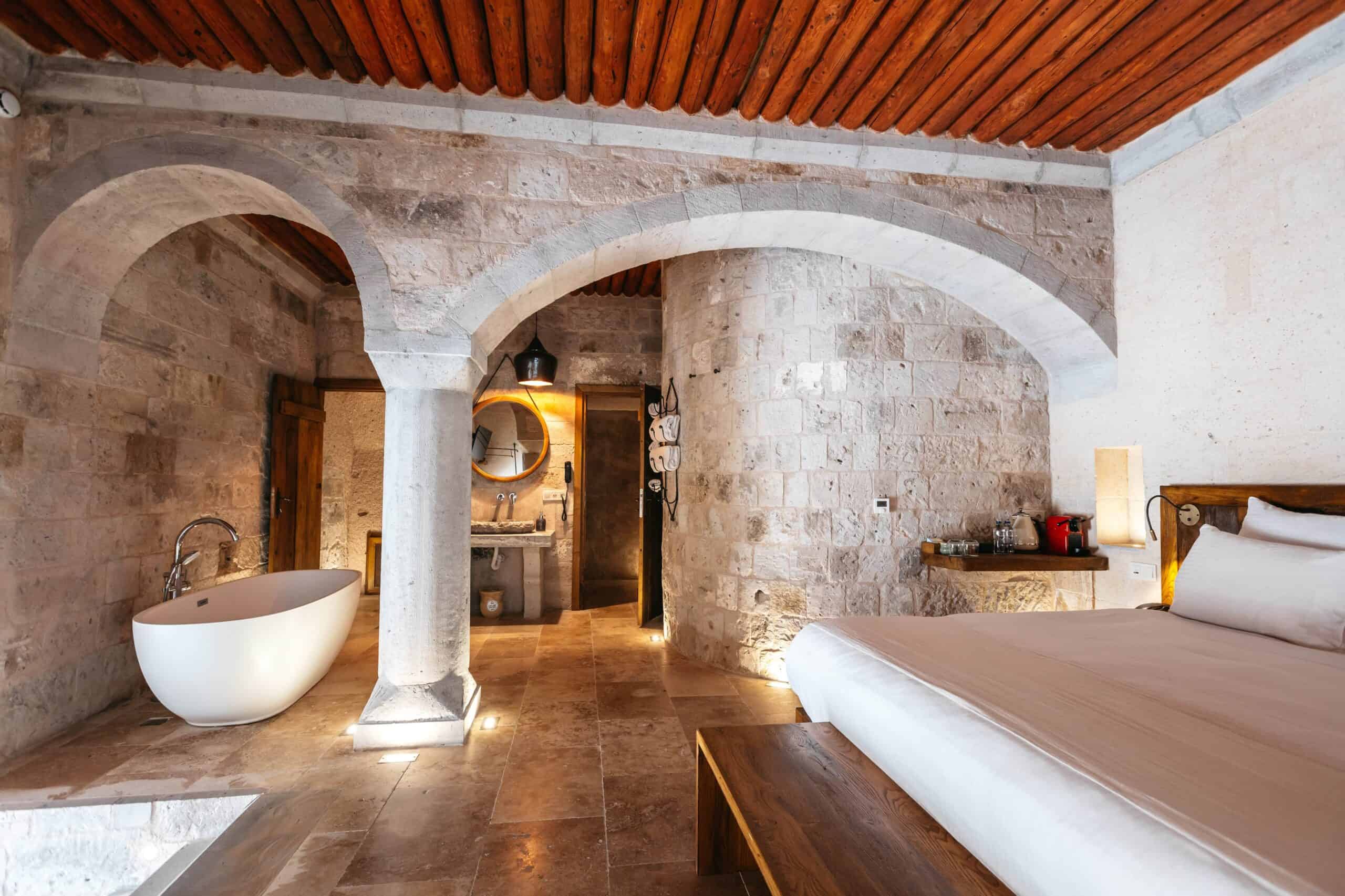 Stone room with a bathtub in the semi-open pool suite at Millstone Cave Suites