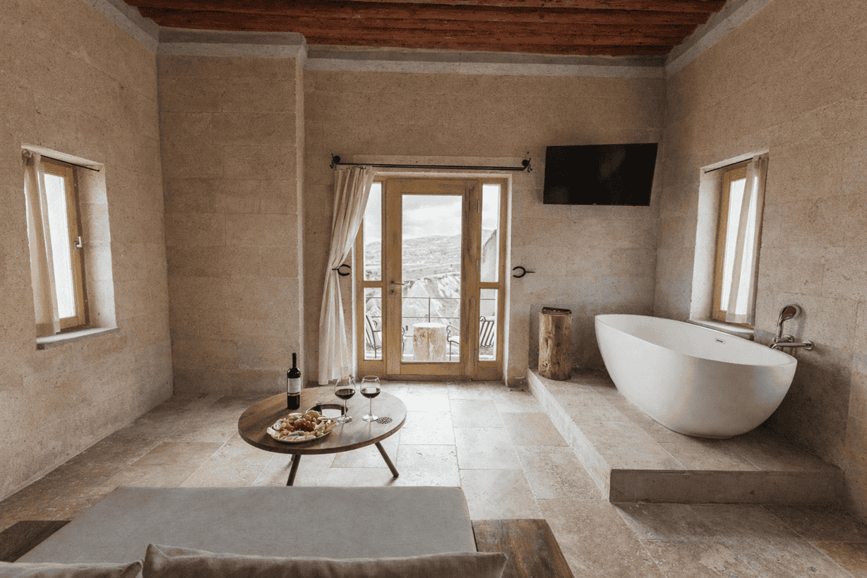 Balcony suite at Millstone Cave Suites featuring a balcony with fairy chimney views and a bathtub with a view.