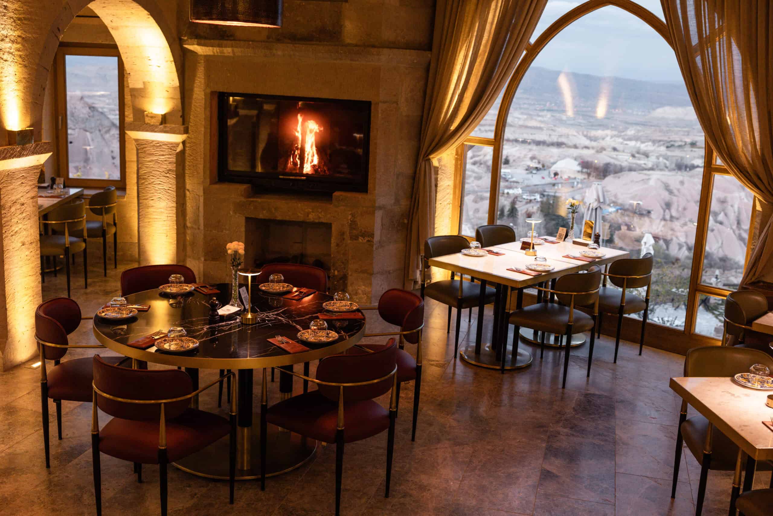 Seating area with a fireplace and valley view at Millstone Cave Suites' Millitaly Restaurant.