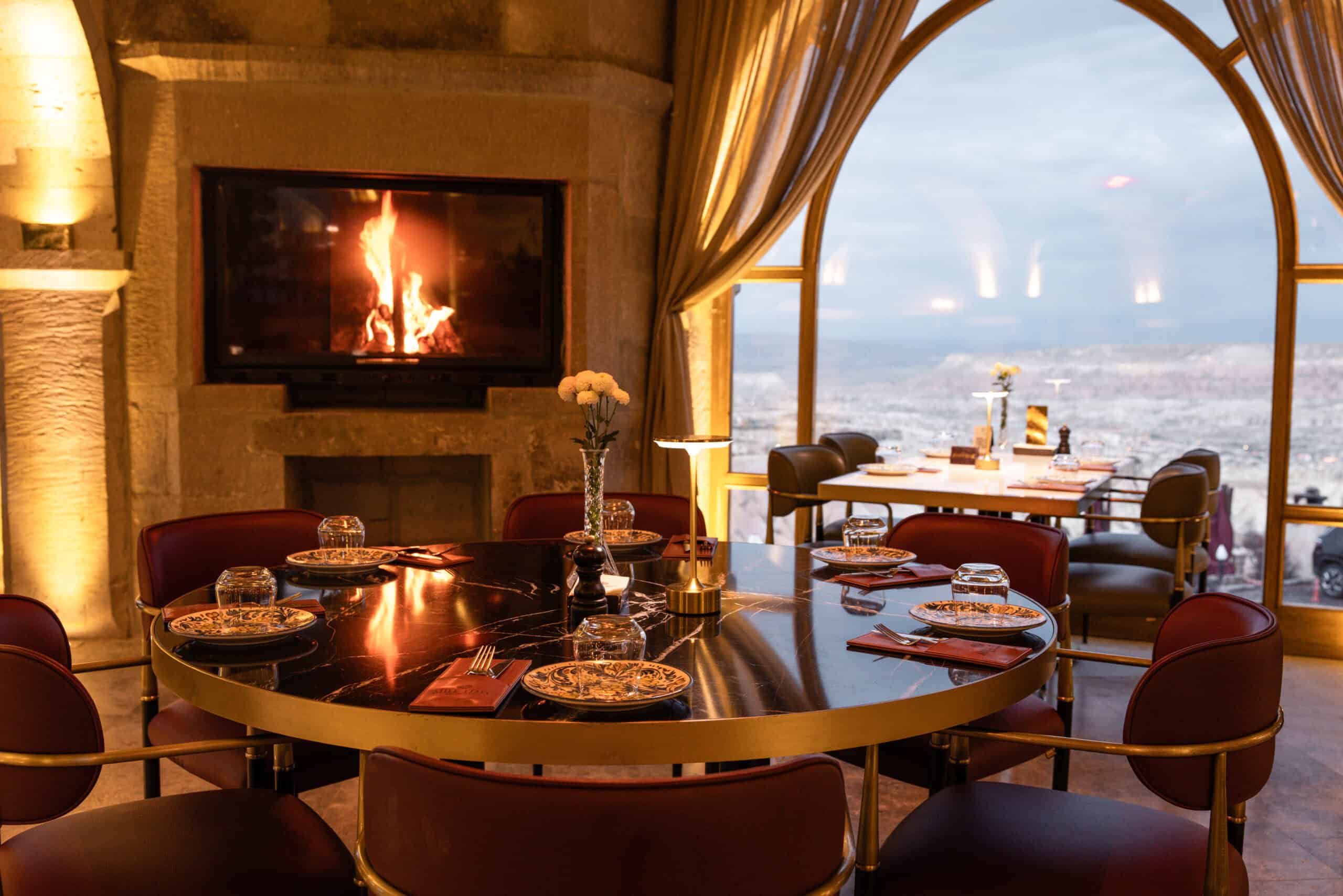 Seating area with a fireplace and valley view at Millstone Cave Suites' Millitaly Restaurant.