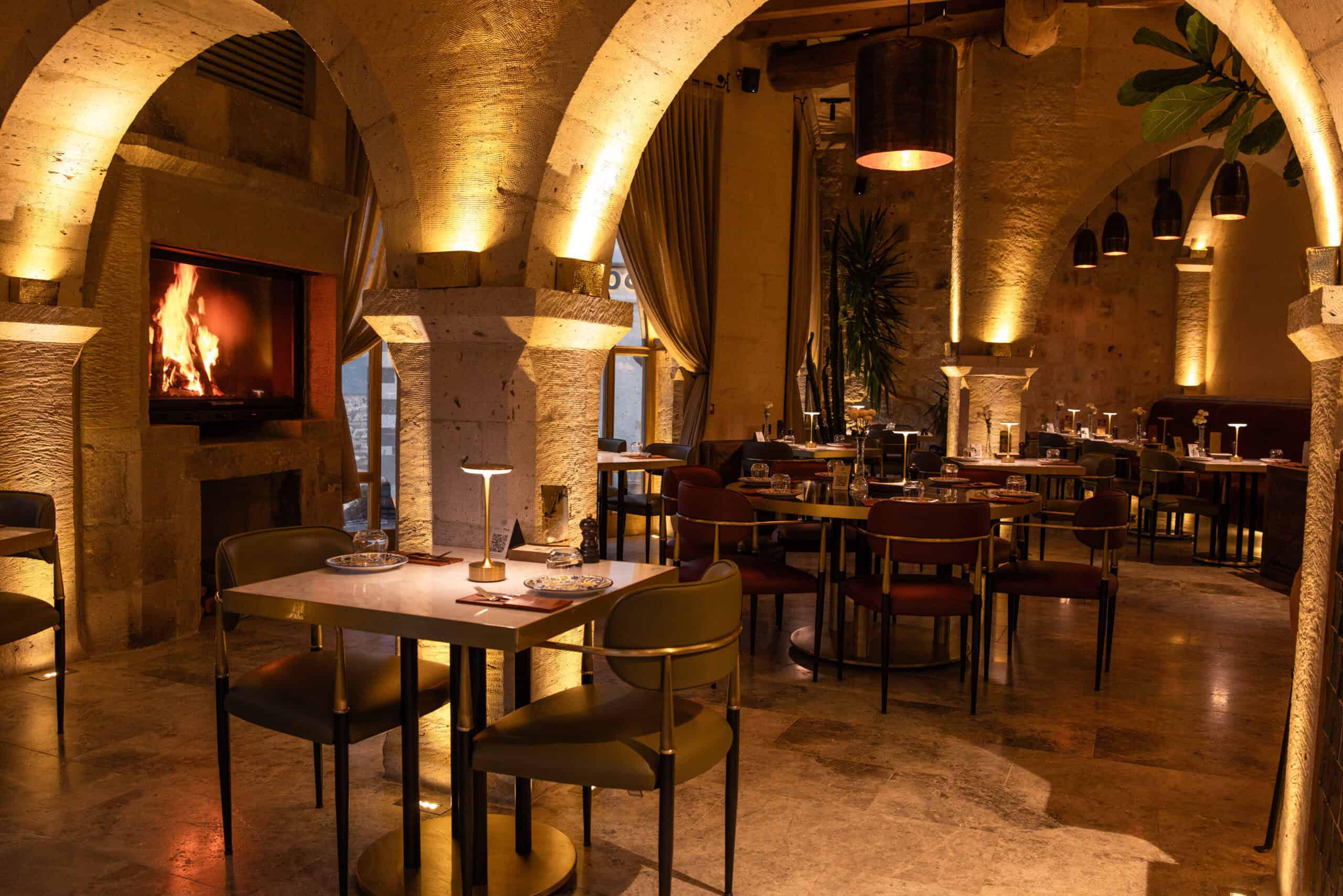 Seating area with a fireplace and valley view at Millstone Cave Suites' Millitaly Restaurant.