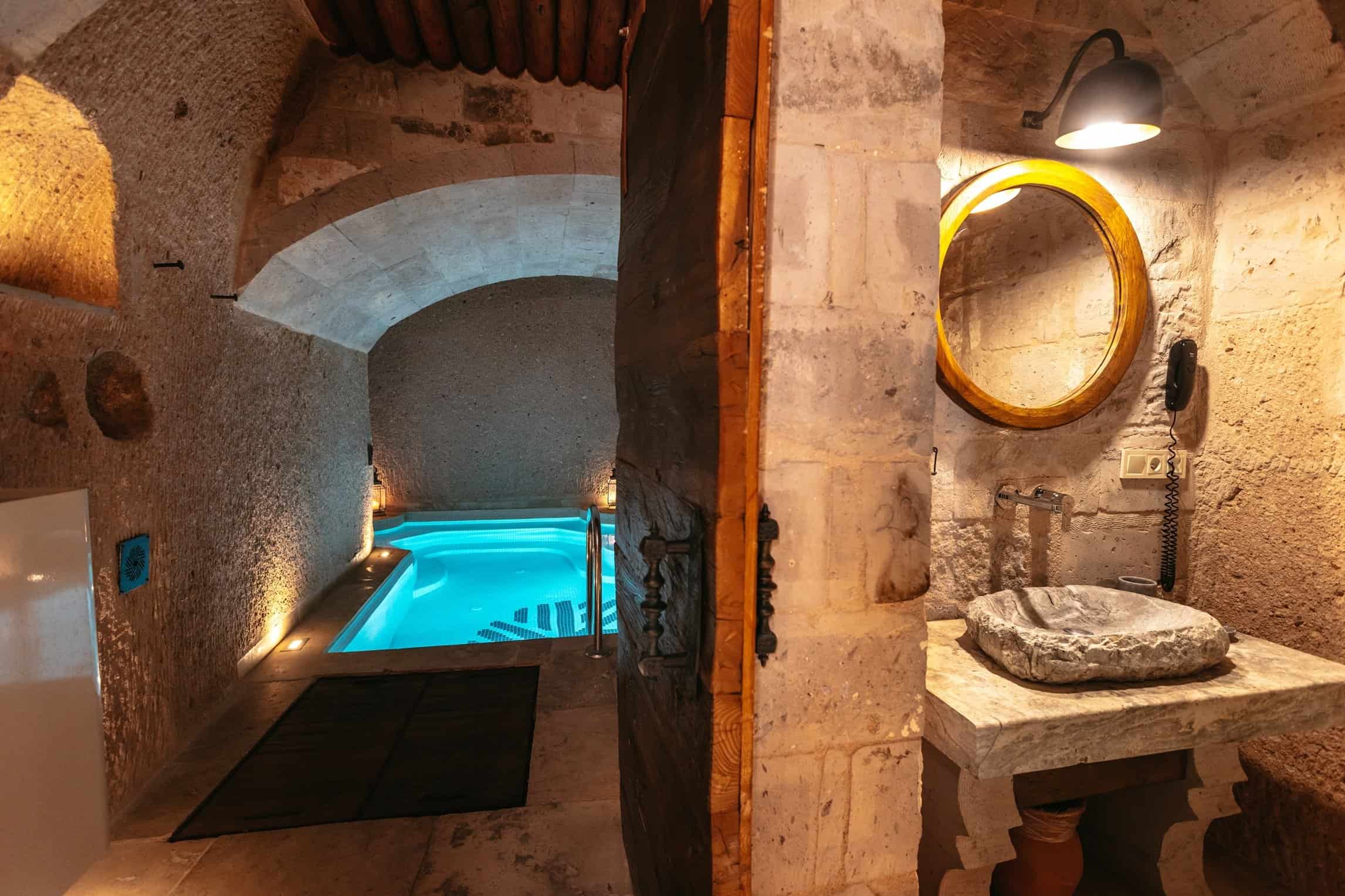 Cave room with a fireplace and an indoor pool in the Pool Suite at Millstone Cave Suites.