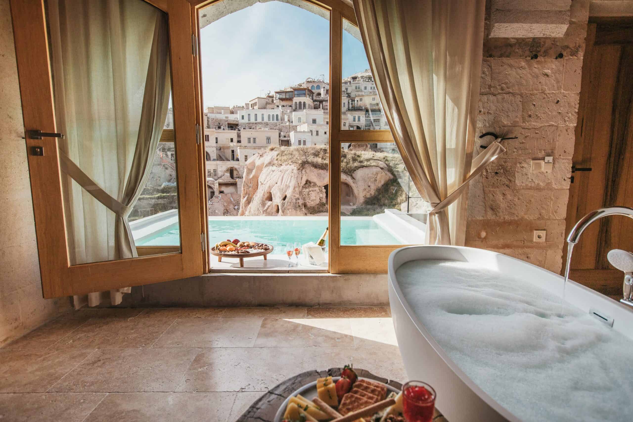 A room with a fireplace, an outdoor pool, and views of fairy chimneys and the castle at Millstone Cave Suites (in the Suite with a Pool and View).