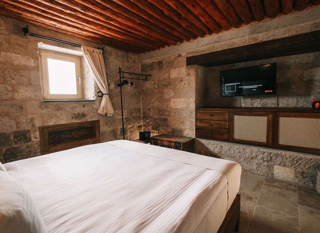 Millstone Cave Suites standard oda'da şömineli taş oda